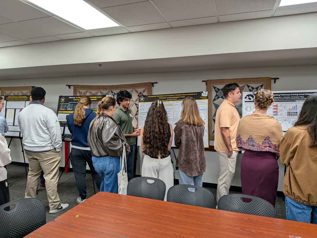 Poster presenters sharing their research with retreat attendees